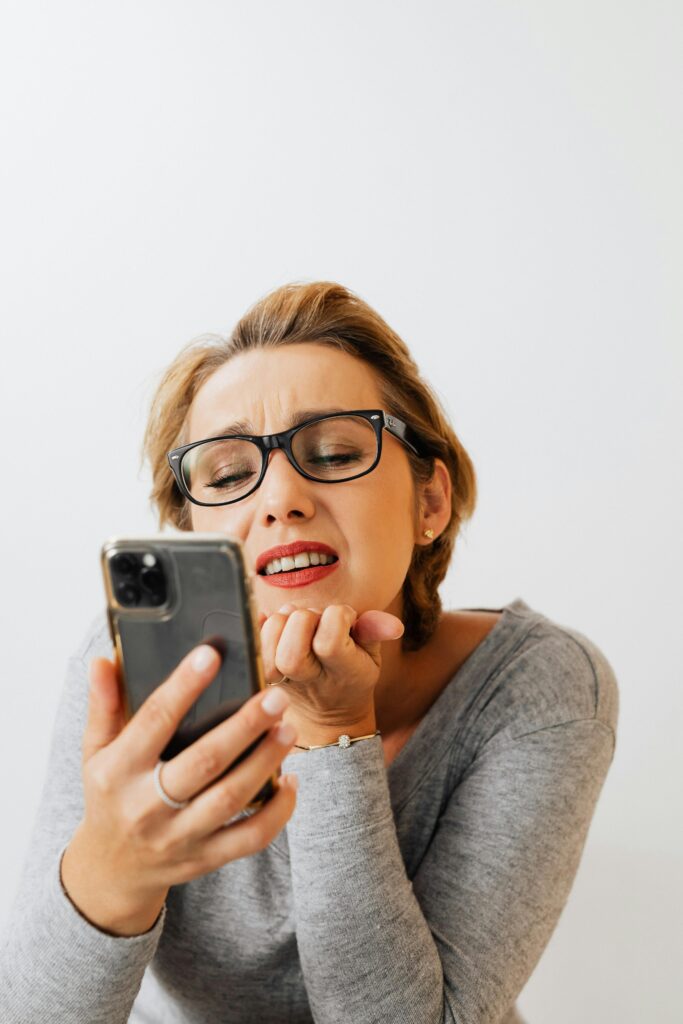 woman looking shocked to her phone